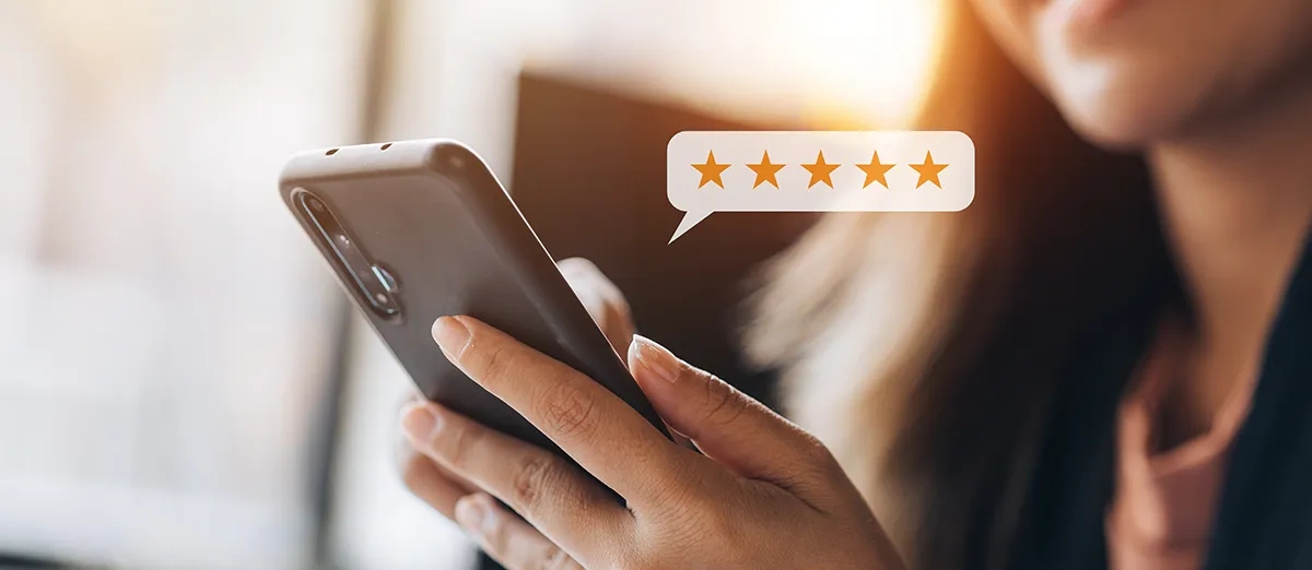 una mujer aparece dejando una reseña positiva en su smartphone